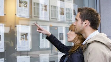 Couple looking at estate agents window display