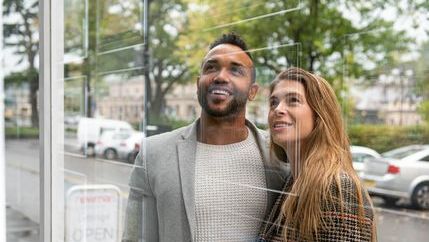 Couple looking in an agent's window