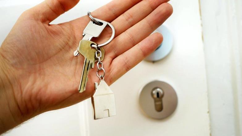 Person holding keys by a door