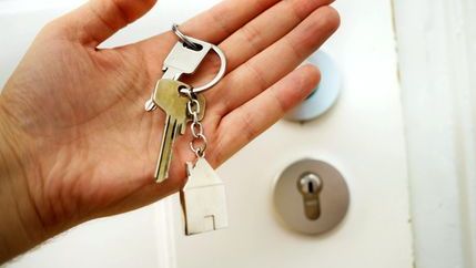 Person holding keys by a door