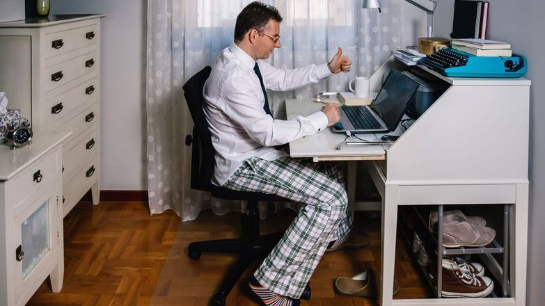 man wearing pyjamas working from home