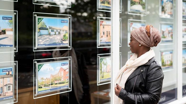 Woman looking at properties in window