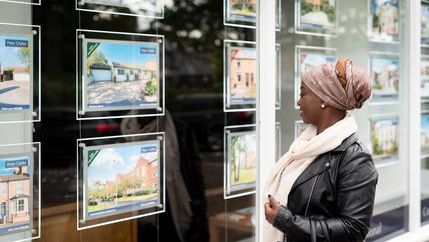 Woman looking at properties in window
