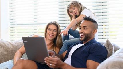 family looking at laptop on the sofa