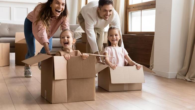 Parents pushing children in cardboard boxes 