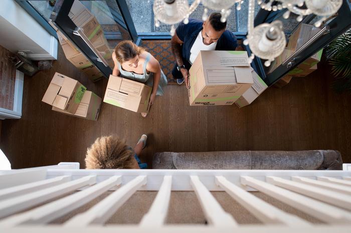 Family bringing boxes into the house