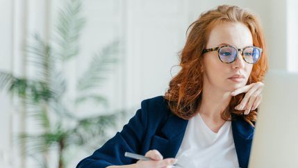 Red headed lady watching a webinar