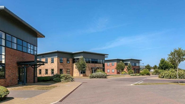 Modern commercial brick faced business units set against blue clear sky