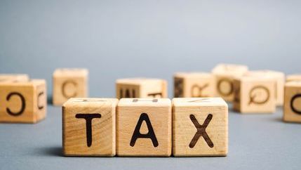 The word tax spelled out on wooden toy blocks