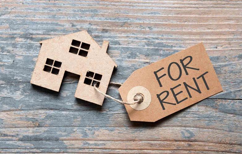 For rent tag attached to wooden model house