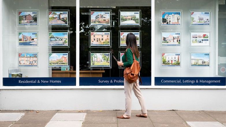 Estate agents window with passer by