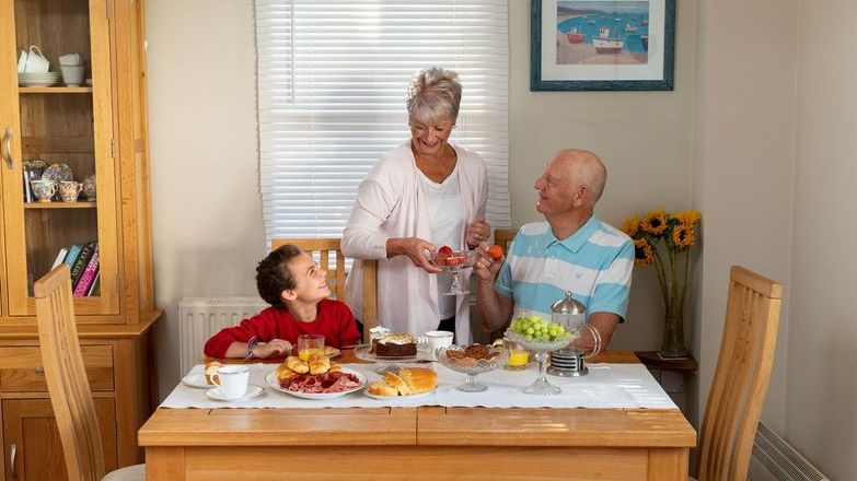 Child with grandparents at a table