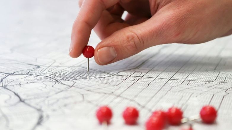 Person placing pin on map.jpg