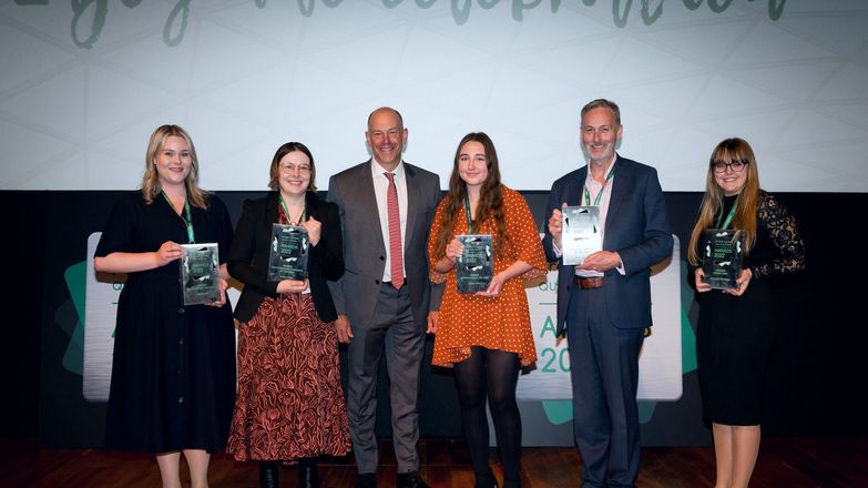 Five winners holding their awards alongside Phil Spencer 