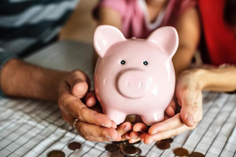 Piggy bank being held protectfully by family