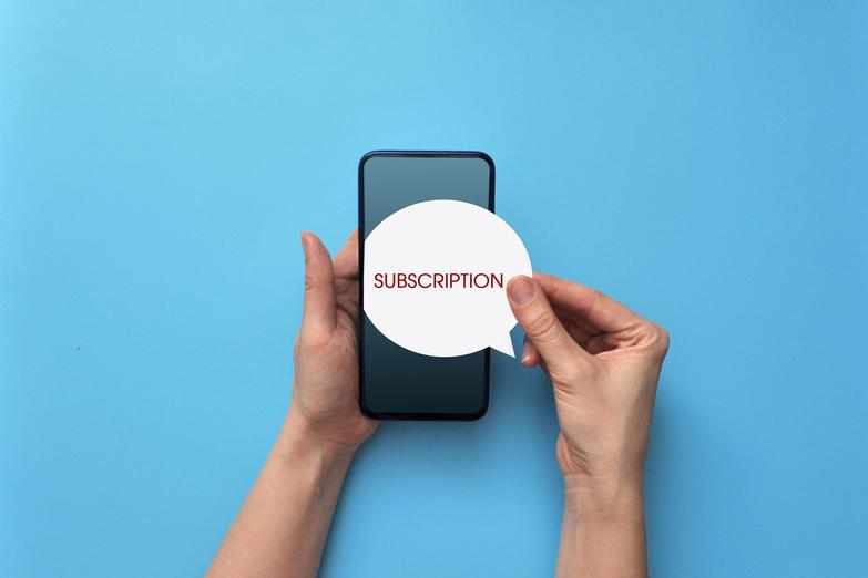 Person holding phone against blue background with a subscription note