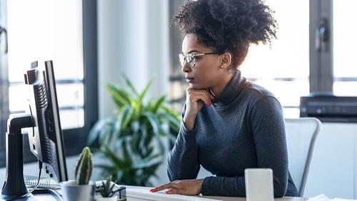 Woman with glasses looking at computer screen
