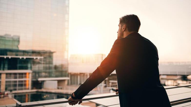 Man looking off office balcony.