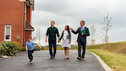 Child running in front of parents and estate agent