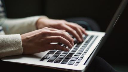 Person typing on silver laptop
