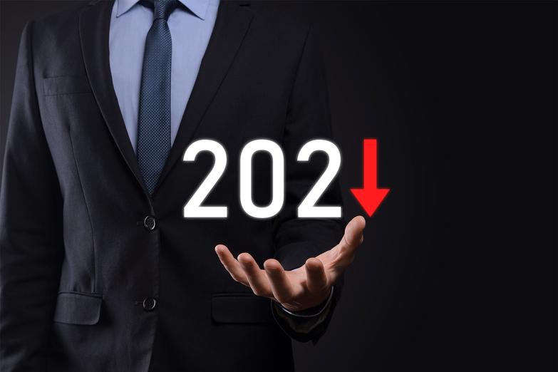 Businessman holding 2021 graphic with downward arrow