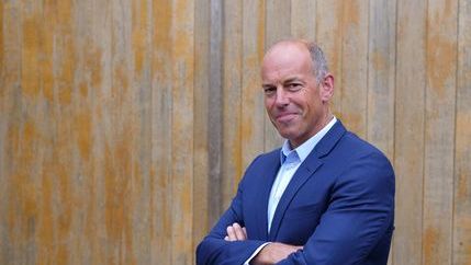 Phil Spencer in blue suit against wooden panelling .jpg