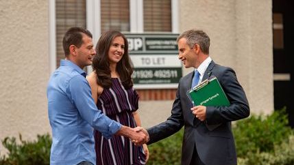Estate agent shaking hands with couple