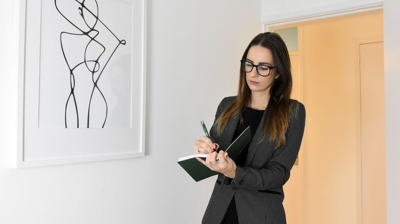 Female inventory clerk making notes during a property inspection