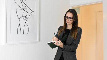 Female inventory clerk making notes during a property inspection