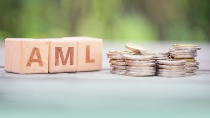 AML blocks next to pile of coins