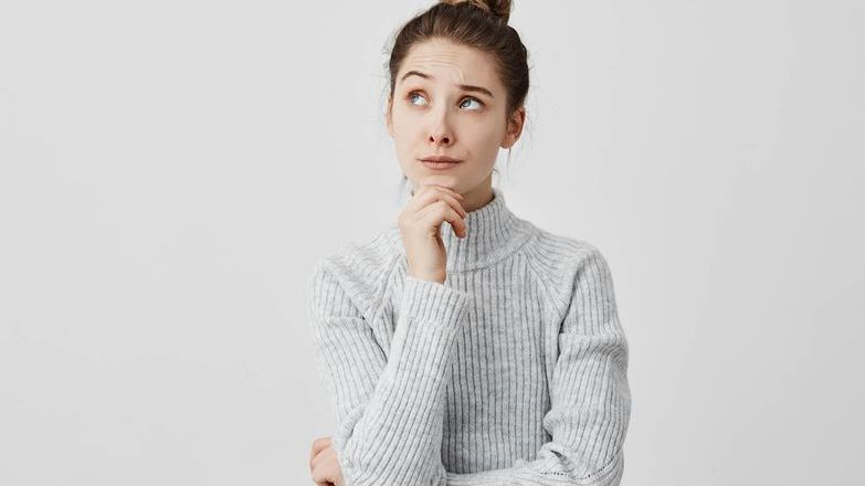 Thinking woman wearing a grey jumper