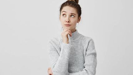 Thinking woman wearing a grey jumper
