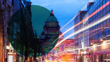 Illuminated Belfast City Hall with traffic motion blur