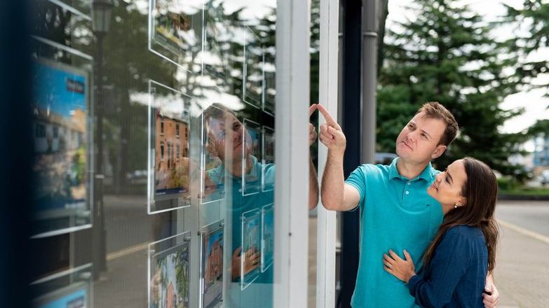 Couple looking in estate agent's window