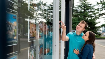 Couple looking in estate agent's window