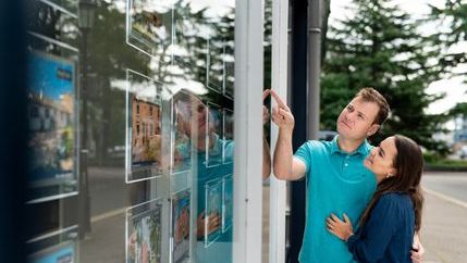 Couple looking in estate agent's window