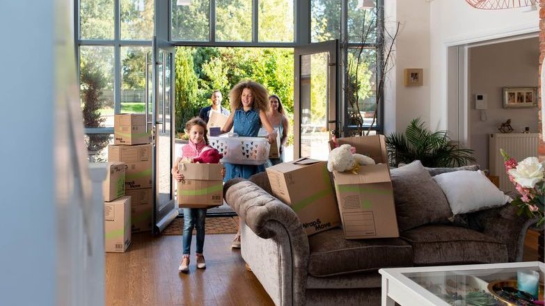 Family bringing boxes into living room