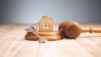Gavel and key with house keyring