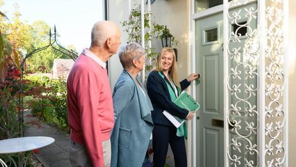 Retired couple entering house with estate agent