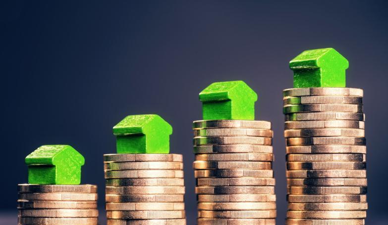 Model houses sitting on top of pound coins