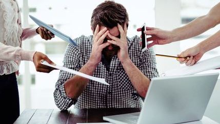 Stressed man with lots going on around him