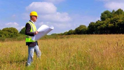 Builder in field with development plans.jpg